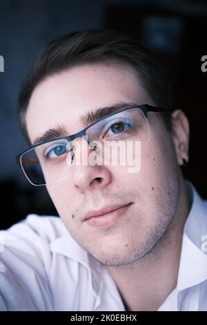 Gros plan sur la création d'un selfie beau et élégant homme en lunettes portant une chemise blanche, jeune homme souriant et atractive visage gros plan dans la lumière du coucher du soleil Banque D'Images