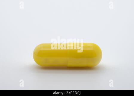 Comprimé de couleur jaune sur fond blanc, médicament, image rognée Banque D'Images