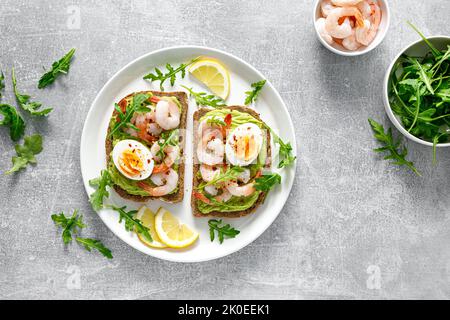 Toast avec crevettes, guacomole d'avocat, arugula et œuf dur, vue du dessus Banque D'Images