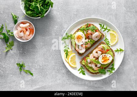 Toast avec crevettes, guacomole d'avocat, arugula et œuf dur, vue du dessus Banque D'Images