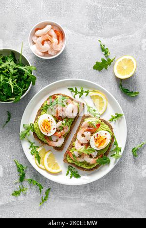 Toast avec crevettes, guacomole d'avocat, arugula et œuf dur, vue du dessus Banque D'Images