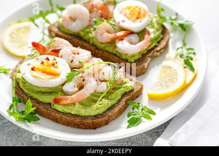 Toast aux crevettes, guacomole d'avocat, arugula et œuf dur Banque D'Images