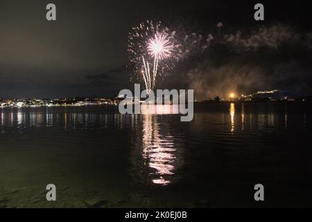 Les feux d'artifice peignent le ciel dans différentes couleurs et sont reflétés dans le lac Miseno, créant une vue à couper le souffle. Banque D'Images