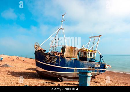 Un bateau de pêche à coque en acier blanc et bleu RX256 repose sur la pente abrupte de bardeaux du Stade, un port de pêche de Hastings Banque D'Images