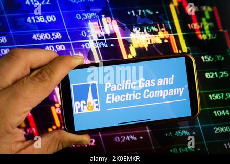 KONSKIE, POLOGNE - 10 septembre 2022: Smartphone affichant le logo de Pacific Gas and Electric Company sur fond de diagramme de la bourse Banque D'Images