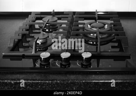 Poêle à gaz noir intégré sur un comptoir noir. Cuisine interier. Banque D'Images