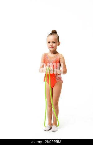 Athlète de gymnastique acrobaties petite fille pose avec corde de saut sur toute la longueur en arrière-plan isolé dans le léopard de sport brillant Banque D'Images