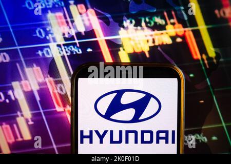 KONSKIE, POLOGNE - 10 septembre 2022: Smartphone affichant le logo de la société Hyundai sur fond de diagramme boursier Banque D'Images