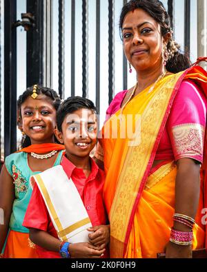 Lewisham, Londres, Royaume-Uni. 11 septembre 2022. Un sourire de famille sur leur chemin dans le temple. Les adorateurs arrivent dans un flux régulier au temple magnifiquement décoré. Les fidèles marquent le Tamil chariot Festival (Ther) avec une célébration colorée. Par respect pour la reine, la procession est aujourd'hui limitée au temple et à la cour de Sivan Kovil. Normalement, environ 5 000 visiteurs et participants se rendaient du temple au centre-ville, transportant de grands chars et des offrandes. Crédit : Imageplotter/Alamy Live News Banque D'Images