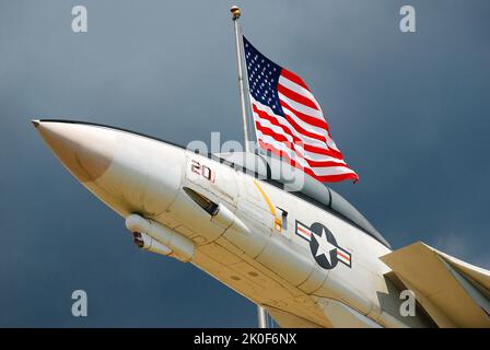 Un Grumman américain F14 Tom Cat semble voler avec un drapeau américain à l'entrée du Musée national de l'aviation navale à Pensacola, en Floride Banque D'Images