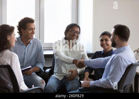 Heureux divers collègues d'affaires hommes serrer la main avec gratitude Banque D'Images