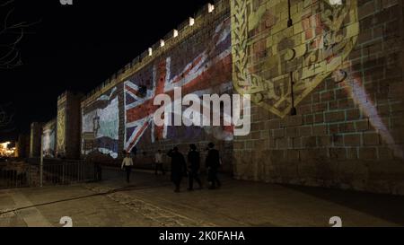 JÉRUSALEM, ISRAËL - SEPTEMBRE 10 : les gens marchent à travers les drapeaux israéliens et de l'Union Jack projetés contre les murs de la vieille ville près de la porte de Jaffa à la suite de la mort de la reine Élisabeth II sur 10 septembre 2022 à Jérusalem, Israël. Le président Isaac Herzog représentera Israël aux funérailles de la reine Elizabeth II, la semaine prochaine à Londres. Crédit : Eddie Gerald/Alay Live News Banque D'Images