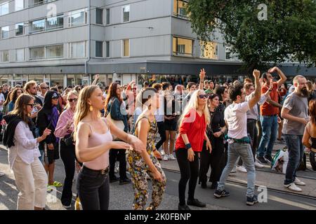 Des personnes dansant dans la rue à la musique de DJ dans le quartier Alppila d'Helsinki, en Finlande Banque D'Images