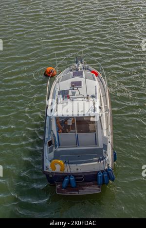 bateau à moteur ou bateau à moteur moderne sur une amarrage balançoire dans la rivière à lymington hampshire royaume-uni, grand bateau à moteur, bateau à moteur de forme traditionnelle, amarré. Banque D'Images