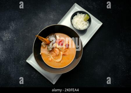 Soupe thaïlandaise aux fruits de mer, sur béton foncé Banque D'Images