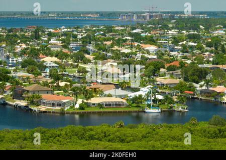 Vue aérienne des banlieues résidentielles avec maisons privées situées près des terres humides sauvages avec végétation verte sur la rive de la mer. Vivre à proximité de la nature concep Banque D'Images