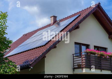 Panneaux photovoltaïques de 6 kW sur le toit marron d'une maison unifamiliale. Énergie écologique du soleil. Bon temps. Banque D'Images