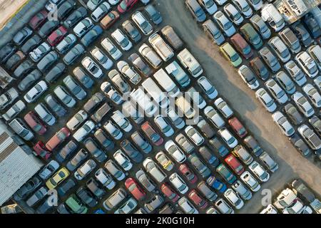 Vue aérienne du grand parking de junkyard avec des rangées de voitures brisées jetées. Recyclage des vieux véhicules Banque D'Images