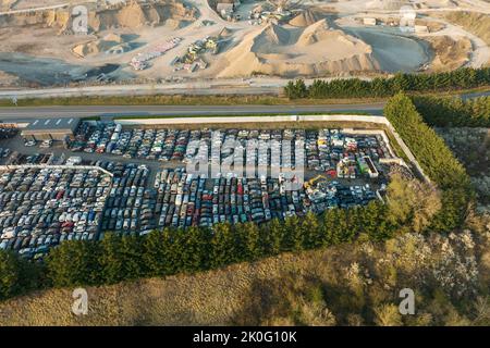 Vue aérienne du grand parking de junkyard avec des rangées de voitures brisées jetées. Recyclage des vieux véhicules Banque D'Images