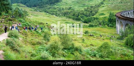 Glenfinnan,Inverness-shire,Scottish Highlands-21 juillet 2022: Une longue file de personnes descendent les pistes surplombant le site emblématique, dans l'après-midi, vers le blanc Banque D'Images