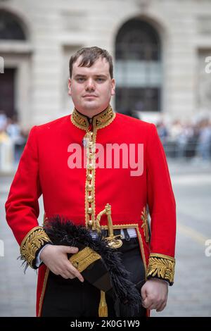 Homme portant un uniforme de l'Armée britannique au pelage rouge debout devant la Royal Exchange dans la City de Londres, au Royaume-Uni Banque D'Images