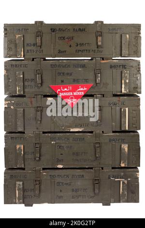 Avertissement de champ de mines arabe/anglais signe rouge - danger Mines sur la pile de munitions de l'armée soviétique de caisses vertes. Texte sur les caisses en russe - type d'ammuniti Banque D'Images