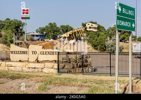 Bord de la route Bienvenue au panneau Glendive avec sculpture métallique d'un dinosaure à Glendive, Montana. Les sculptures sont un hommage aux nombreux os de dinosaures Banque D'Images