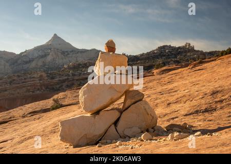 Cairn se tenant sur un grès orange avec Ferns Nipple en arrière-plan dans le parc national de Capitol Reef Banque D'Images