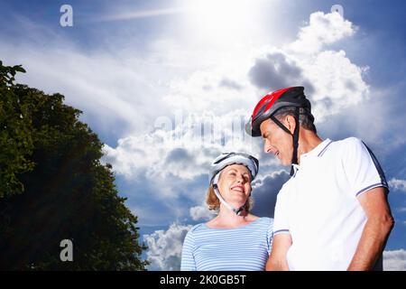 Couple aimant portant un casque de protection contre le ciel nuageux. Portrait d'un couple aimant portant un casque de protection contre le ciel nuageux. Banque D'Images