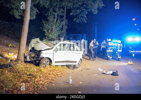 Cologne, Allemagne. 11th septembre 2022. Des policiers et des pompiers se tiennent à côté de la voiture qui s'est écrasée. Cinq personnes se sont heurtées à une voiture dans un arbre à Cologne et ont été blessées, dont quatre grièvement. Credit: Vincent Kempf/dpa/Alay Live News Banque D'Images