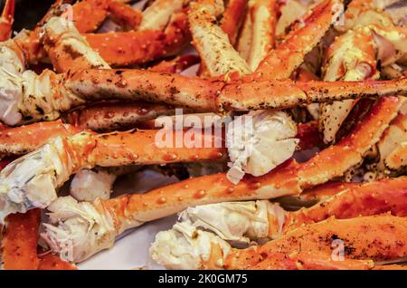 Délicieuses pattes de crabe royal cuites empilées sur du papier de boucherie - prêt à manger - mise au point sélective Banque D'Images