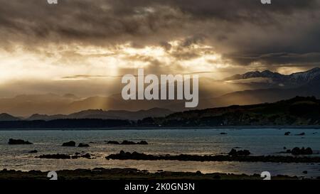 Vue vers l'ouest sur Goose Bay au coucher du soleil, Kaikoura, île sud, Aotearoa / Nouvelle-Zélande. Banque D'Images