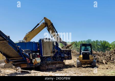 Avec l'aide d'une déchiqueteuse industrielle, nous détruisons les racines des terres en cours de préparation pour l'aménagement de logements Banque D'Images