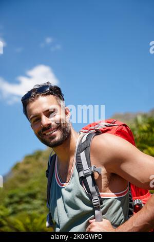 Un étirement supplémentaire vers le haut. Un randonneur avec un sac à dos sur son dos. Banque D'Images