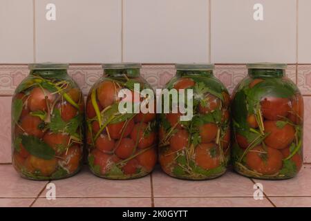 Quelques pots de tomates marinées, concept de recette. Tomates marinées maison dans la cuisine. Banque D'Images