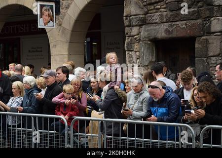 Edinburgh, Écosse, Royaume-Uni, 11 septembre 2022. Le convoi de sa Majesté la reine Elizabeth II a passé le Royal Mile après avoir voyagé par la route de Balmoral. Les gens dans la foule vérifient leurs photos de téléphone avec une jeune fille toujours regarder vers le convoi. Crédit sst/alamy nouvelles en direct Banque D'Images