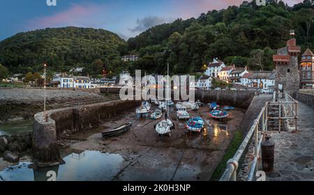 Au crépuscule, les lumières commencent à s'allumer autour du petit port pittoresque de Lynmouth, sur la côte nord de Devon. Lynmouth se trouve au confluent Banque D'Images