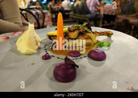 Gros plan de foie gras poêlé servi avec du pain grillé au gingembre croustillant et de la salade balsamique verte Banque D'Images