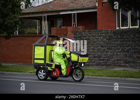 Poste de poste d'Australie sur un véhicule électrique de livraison à trois roues Kyburz DXP, pendant une journée sombre Banque D'Images