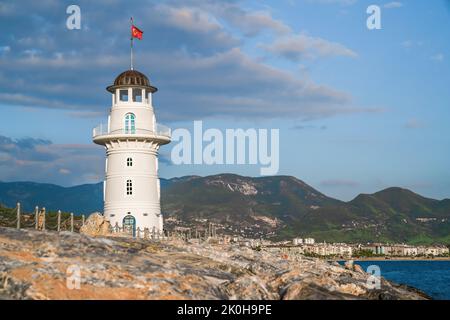 Turquie, Alanya - 9 novembre 2020: Phare blanc de port sur le fond des montagnes et du ciel et de la mer. Copier l'espace Banque D'Images