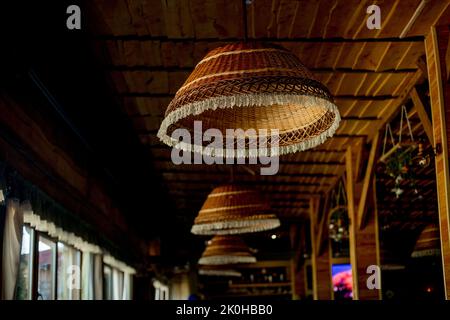 Lampes en osier, toit en bois. Décoration intérieure tendance d'un café hippster dans un style loft. Banque D'Images