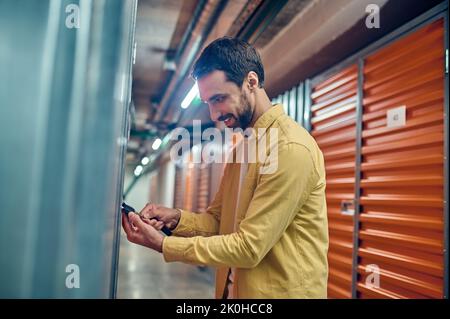 Homme concentré sur le cadenassage de la porte de l'unité de stockage Banque D'Images