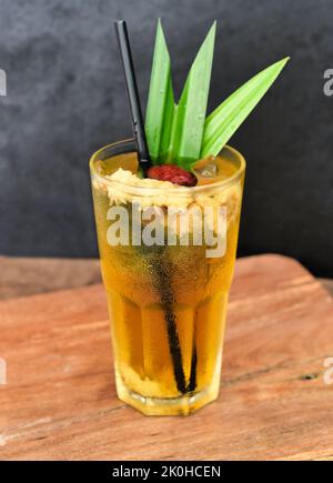 Thé glacé à la camomille avec baie de goji sur une table en bois Banque D'Images