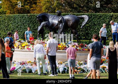 Newmarket, Royaume-Uni. 11 septembre 2022. Hommages floraux laissés à la mémoire de la reine Elizabeth II après sa mort le 8th septembre sur une statue en bronze conçue par Etienne Millner, qui est située à l'entrée de l'hippodrome de Newmarket qui a été un cadeau de la ville l'année de son anniversaire de 90th. Crédit : Mark Bullimore/Alamy Live News Banque D'Images