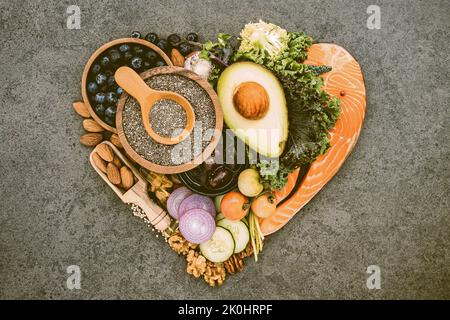 Une forme de coeur de cétogène bas carbs régime, des ingrédients gras insaturés sains sur fond sombre Banque D'Images