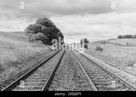 Voies ferrées s'étendant sur la distance entourée par la campagne à Northumberland, dans le nord de l'Angleterre. Tourné sur 35mm films noir et blanc. Banque D'Images