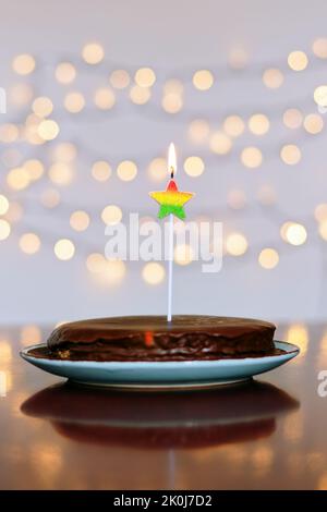 Gâteau d'anniversaire festif avec bougies et décoration de carnaval colorée sur fond de bokeh lumineux. Carte de vœux. Fête et fête Banque D'Images