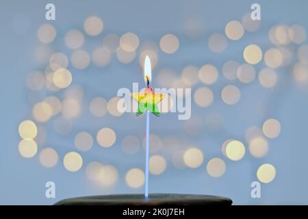 Gâteau d'anniversaire festif avec bougies et décoration de carnaval colorée sur fond de bokeh lumineux. Carte de vœux. Fête et fête Banque D'Images