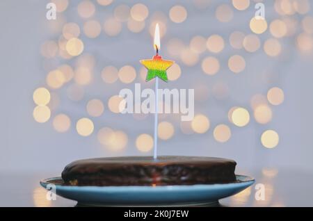 Gâteau d'anniversaire festif avec bougies et décoration de carnaval colorée sur fond de bokeh lumineux. Carte de vœux. Fête et fête Banque D'Images