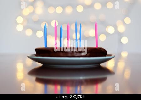 Gâteau d'anniversaire festif avec bougies et décoration de carnaval colorée sur fond de bokeh lumineux. Carte de vœux. Fête et fête Banque D'Images